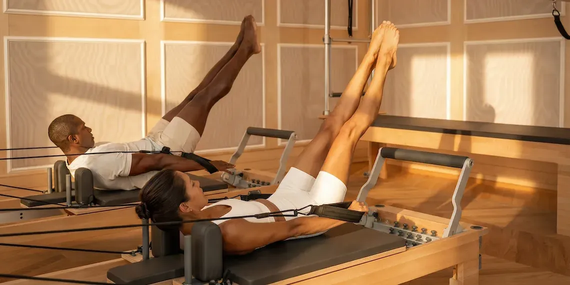 man en vrouw doen Pilates op reformer machines