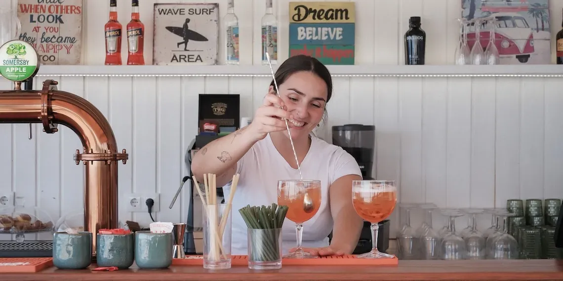 vrouw maakt cocktail bij de bar