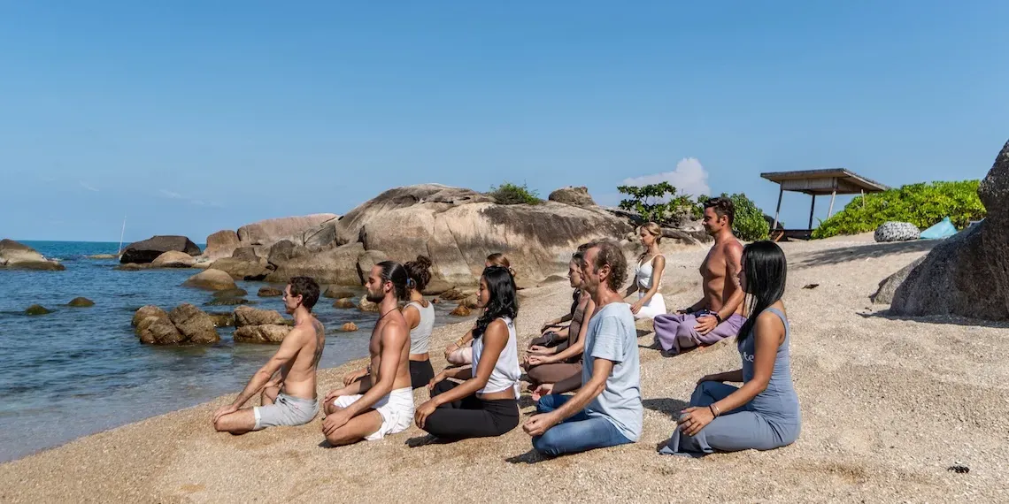 groep mensen doen yoga op het strand