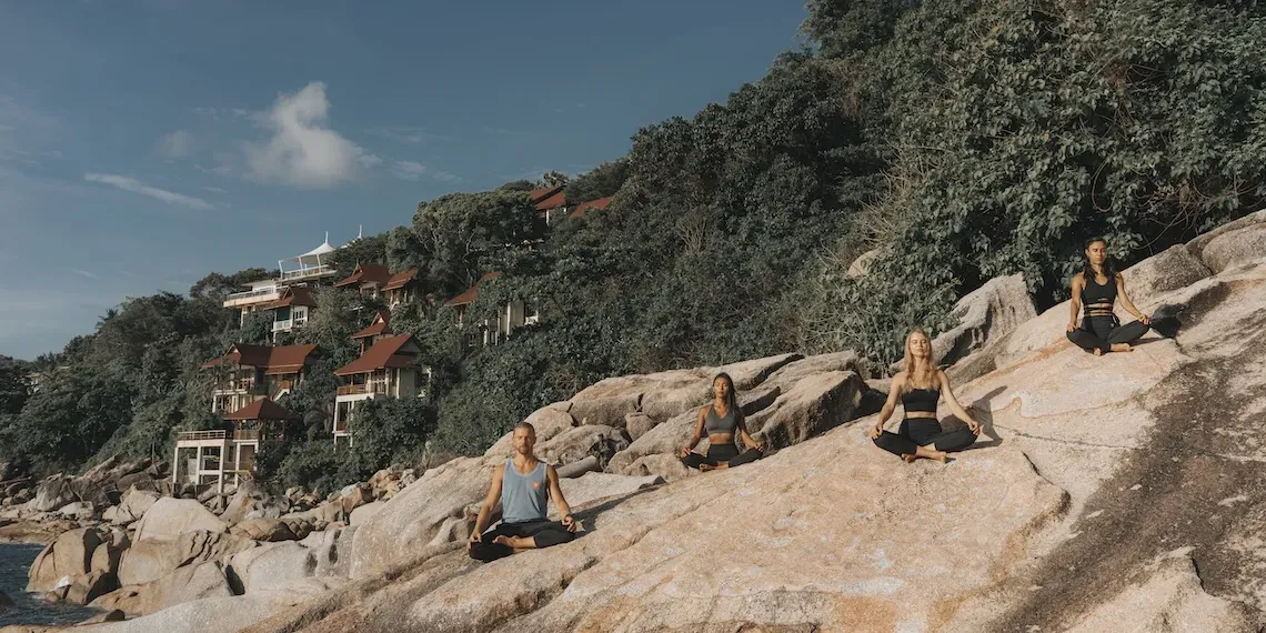 groep mensen doet lotus pose yoga op de stenen