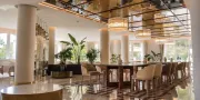 restaurant met grote tafel, stoelen en een glazen plafond