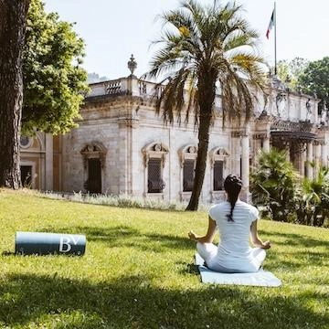 vrouw zit in yogapose voor een oud Italiaans gebouw